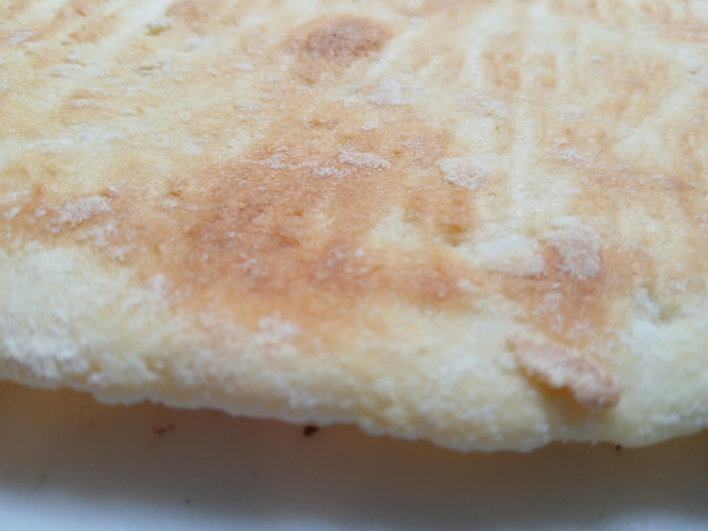 Close-up of a round, flat bread with a slightly browned top gluten free
