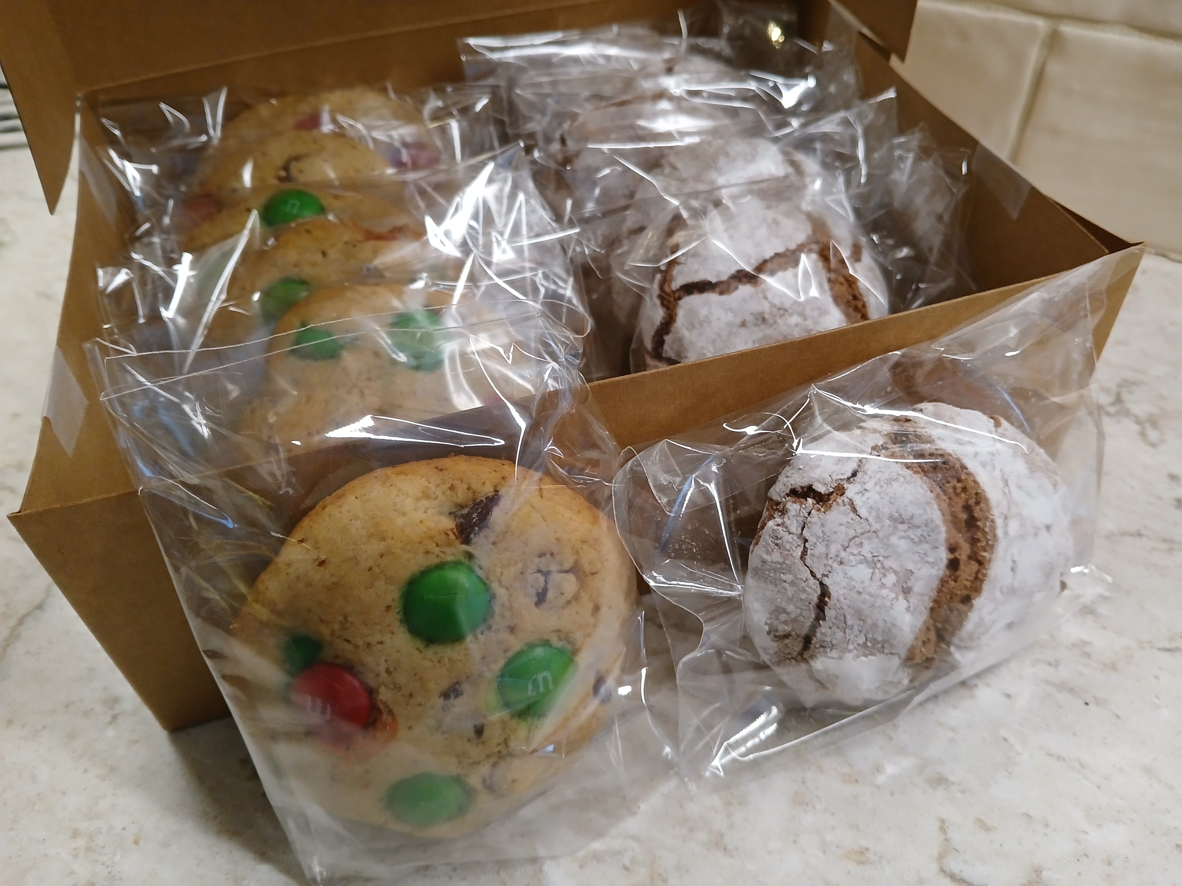 Box of assorted gluten-free cookies with clear packaging gift box