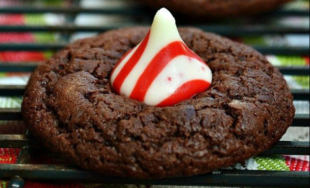 Chocolate peppermint gluten-free cookies with Hershey's Kisses on a cooling rack.