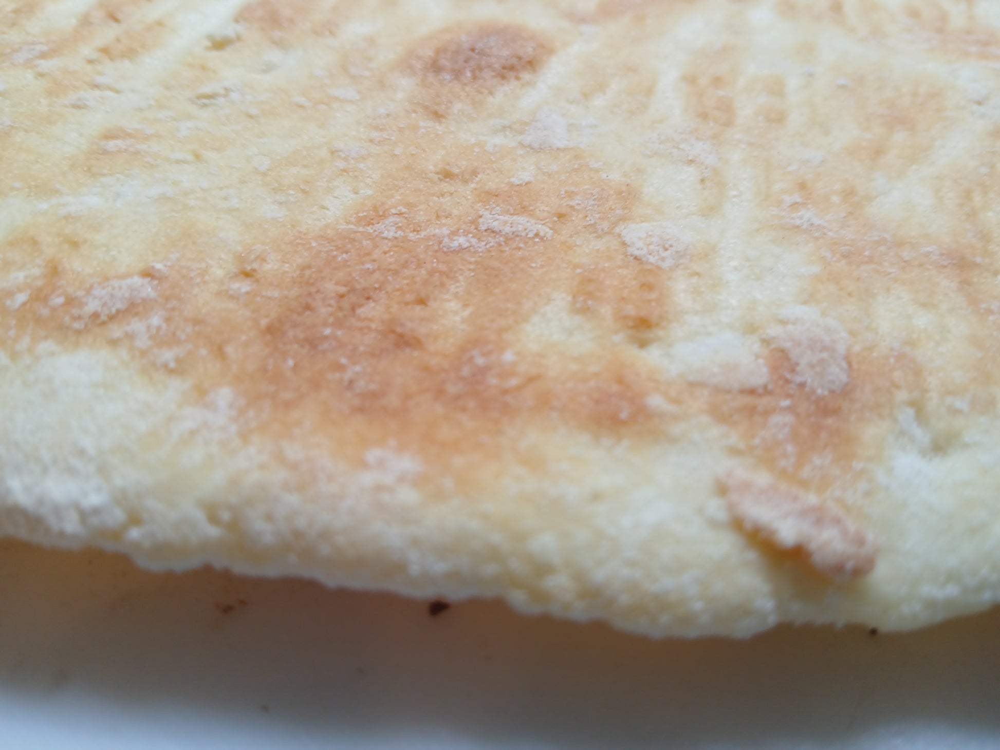 Close-up of a round, flat bread with a slightly browned top gluten free