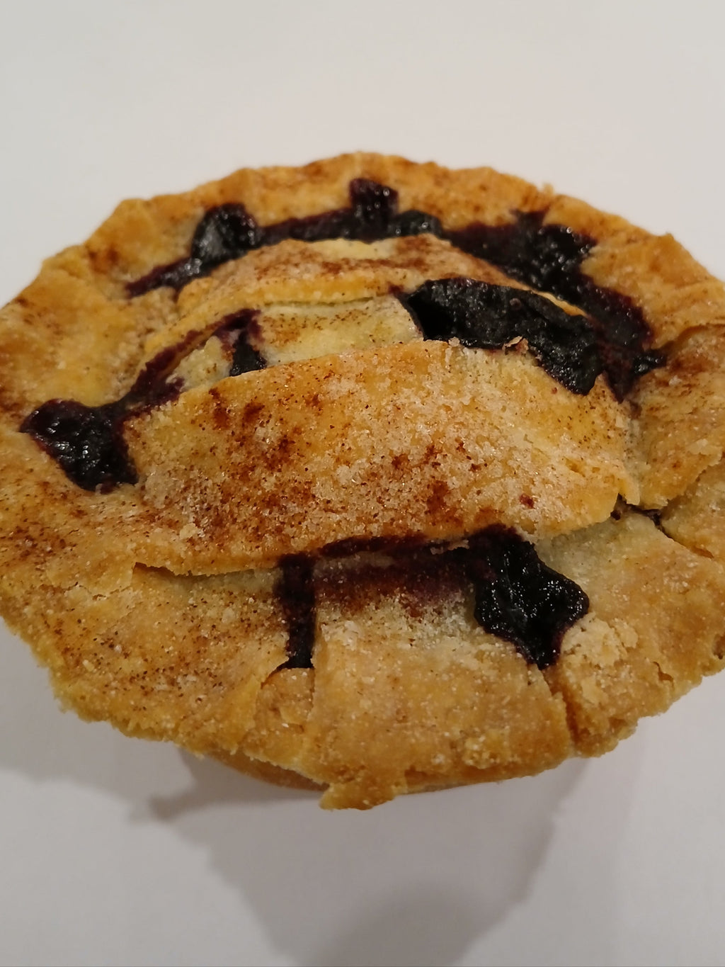 Blueberry pie gluten free on a white plate with a blurred background