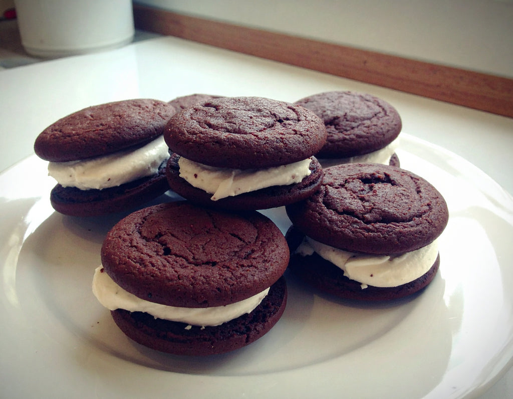 Chocolate sandwich cookies with cream filling on a white plate